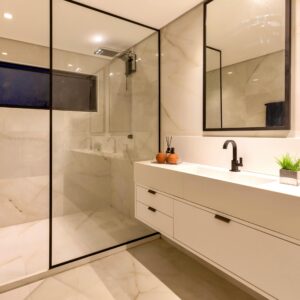 Elegant marble bathroom with a glass shower and stylish decor in Salvador, Brazil.