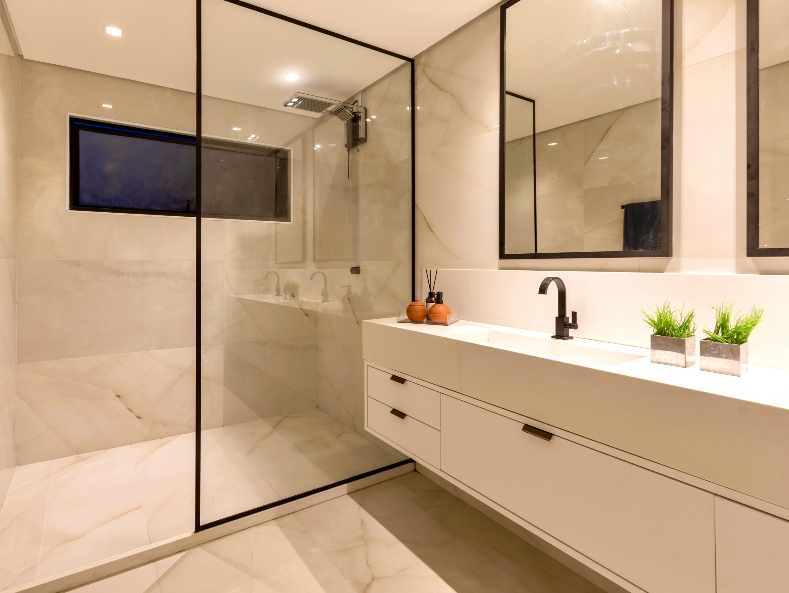 Elegant marble bathroom with a glass shower and stylish decor in Salvador, Brazil.